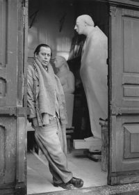 Gustav Seitz vor seinem Atelier in der Kantstraße 1949. Im Hintergrund: Überlebensgroßer schreitender Villon und Dicke Margot. Foto: Gerhard Kiesling © Gustav Seitz Stiftung